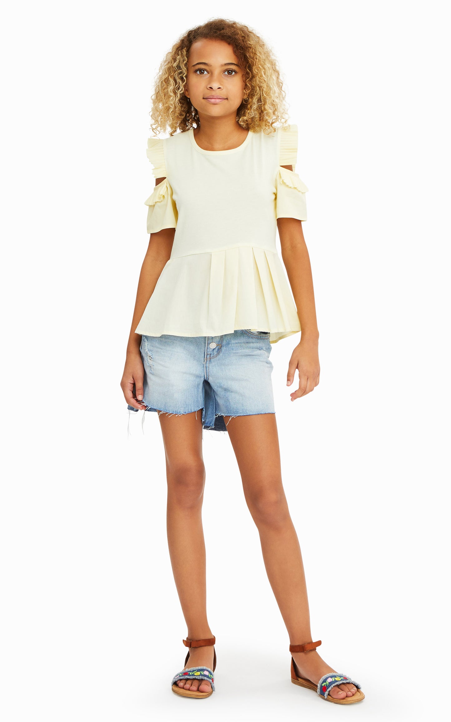 GIRL IN PALE YELLOW PLEATED PEPLUM TOP AND RIPPED JEAN SHORTS