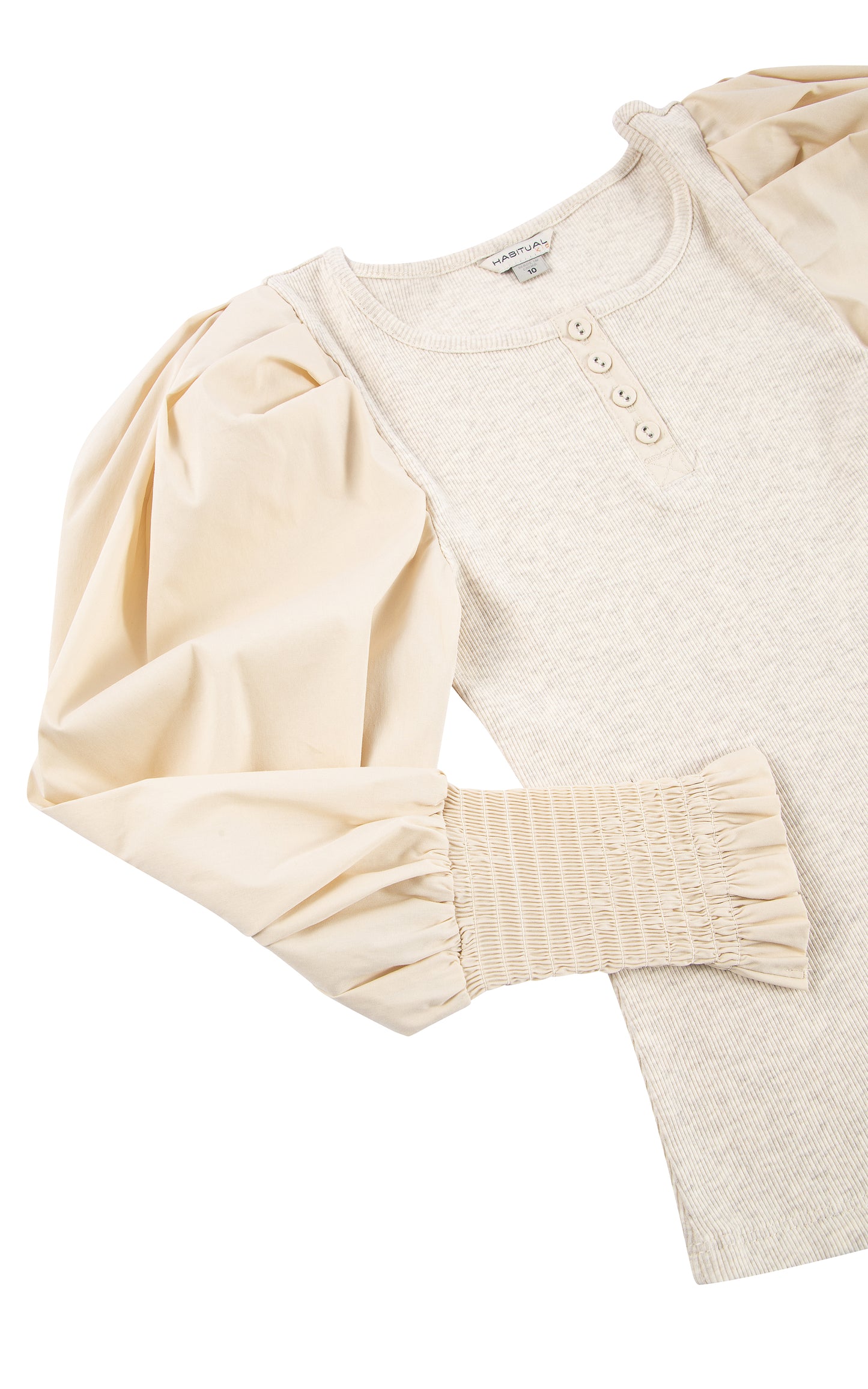 CLOSE UP OF OATMEAL LONG-SLEEVE TOP WITH FOUR BUTTONS AT THE COLLAR, PUFFY SLEEVES, AND SMOCKED CUFFS