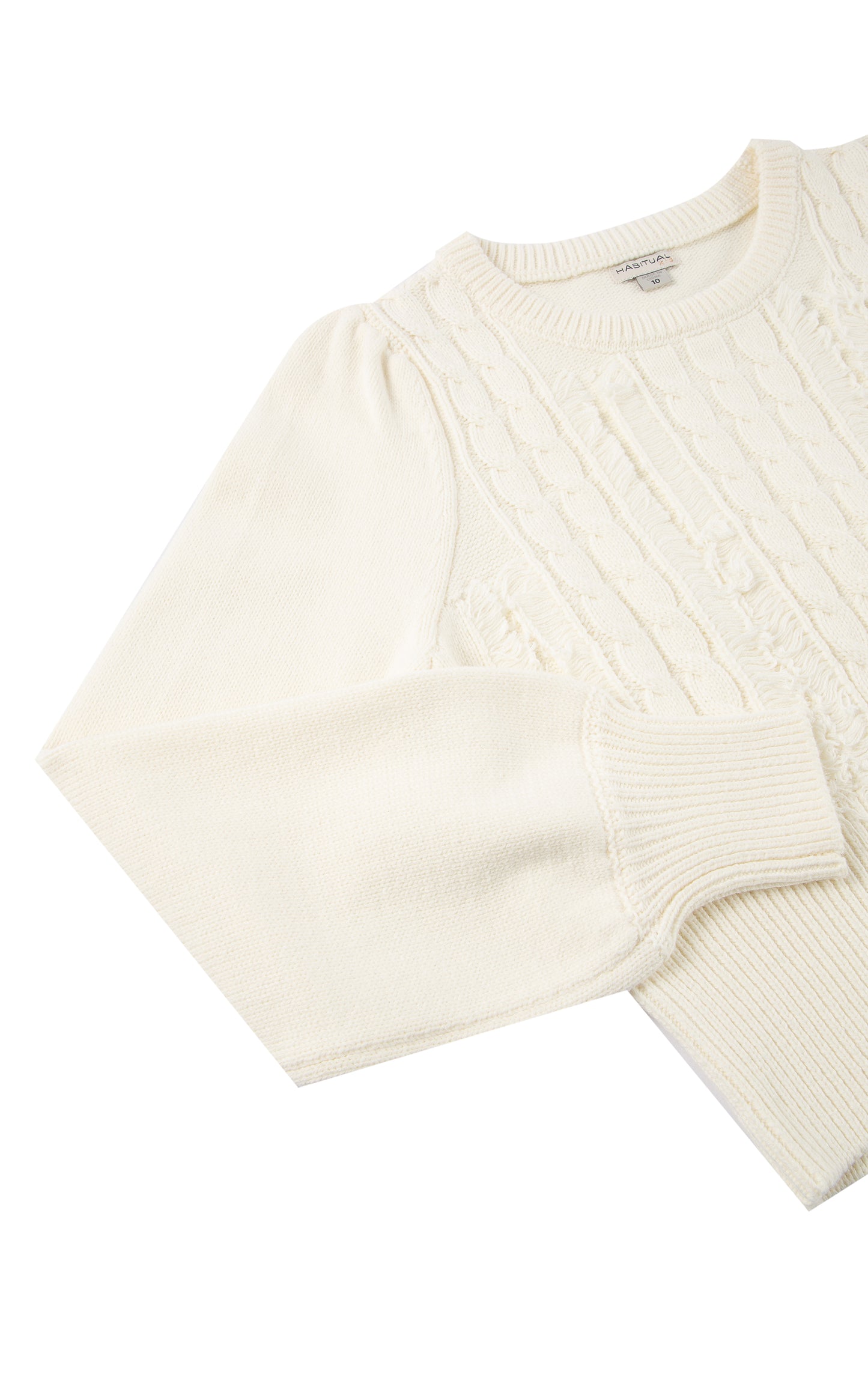 Detail view of an off-white cable-knit sweater with fringe detailing