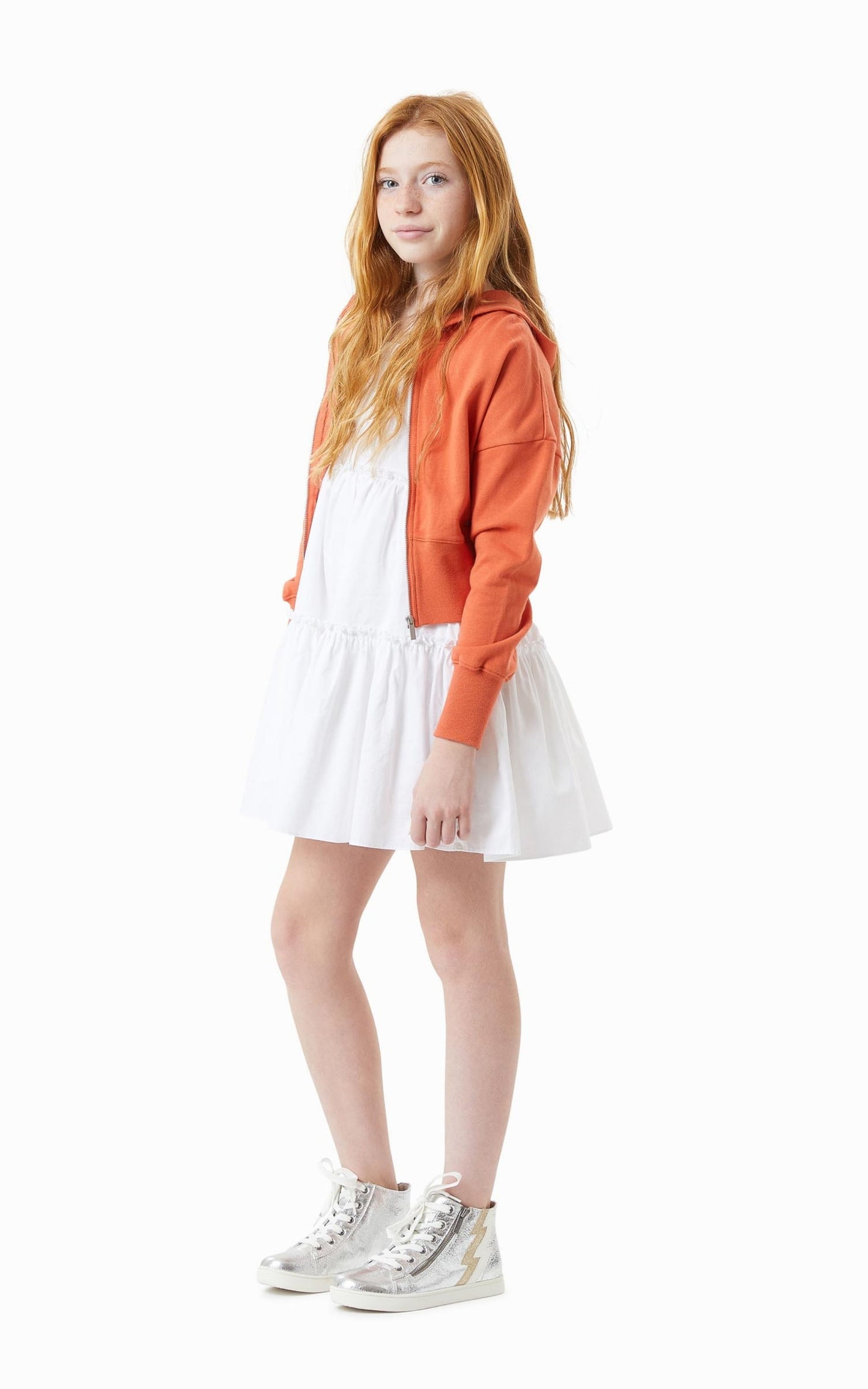 Side View Pre-teen Child in a White Mid-Thigh Summer Dress and Orange Zip up hoodie 