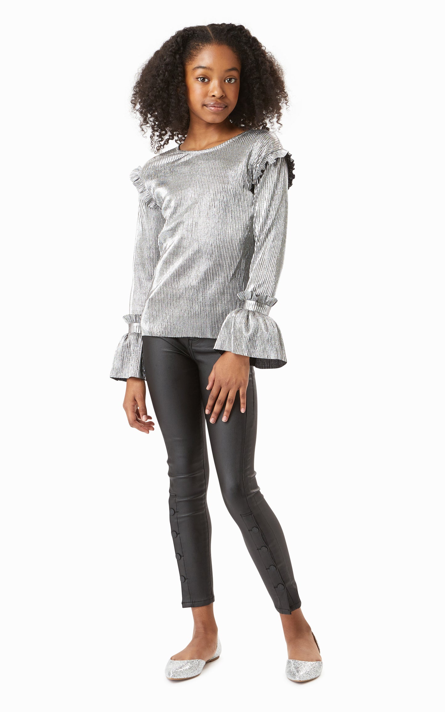 Girl wearing metallic silver long-sleeve top with leather-look skinny jeans. 