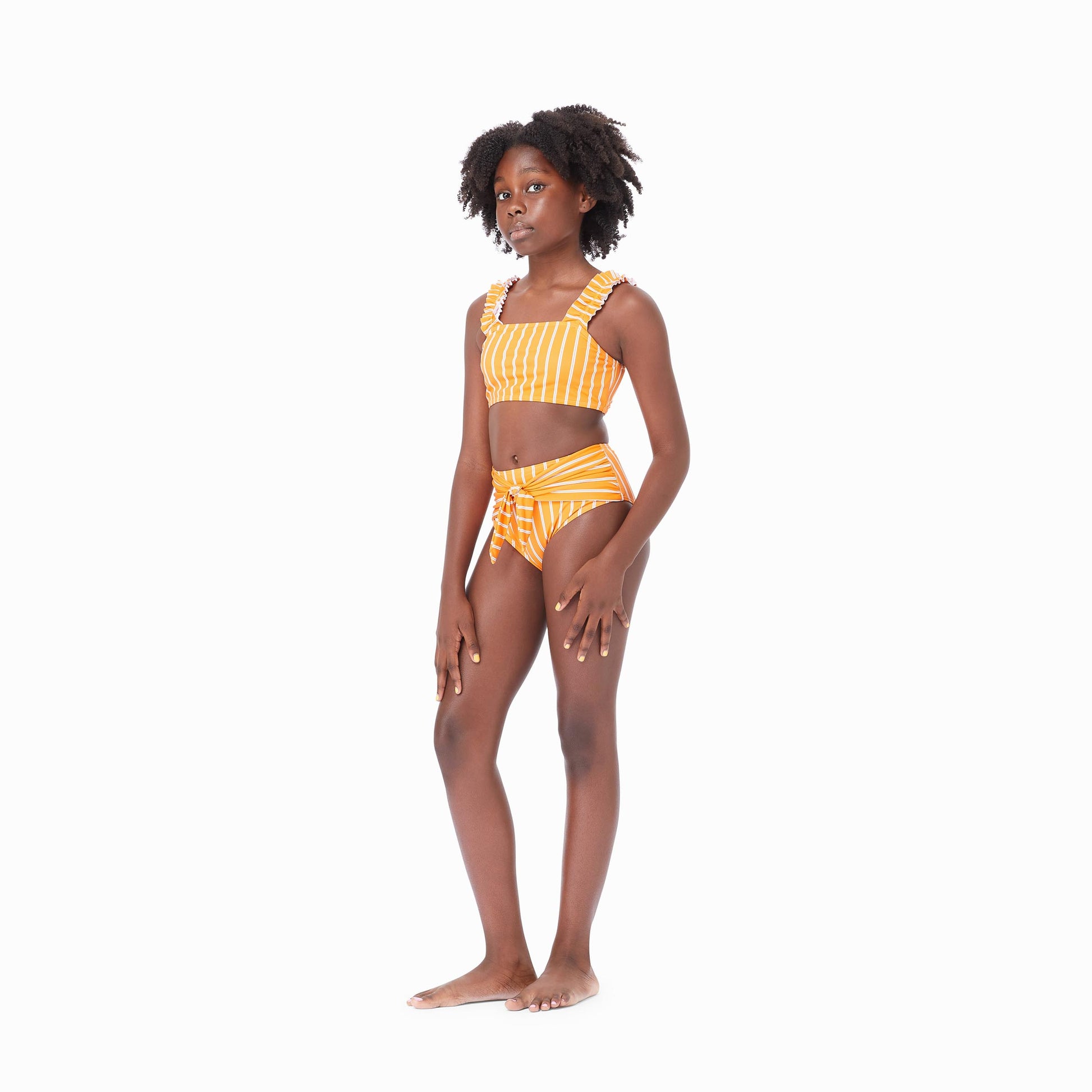 Girl wearing orange two-piece swimsuit with white stripes and bow