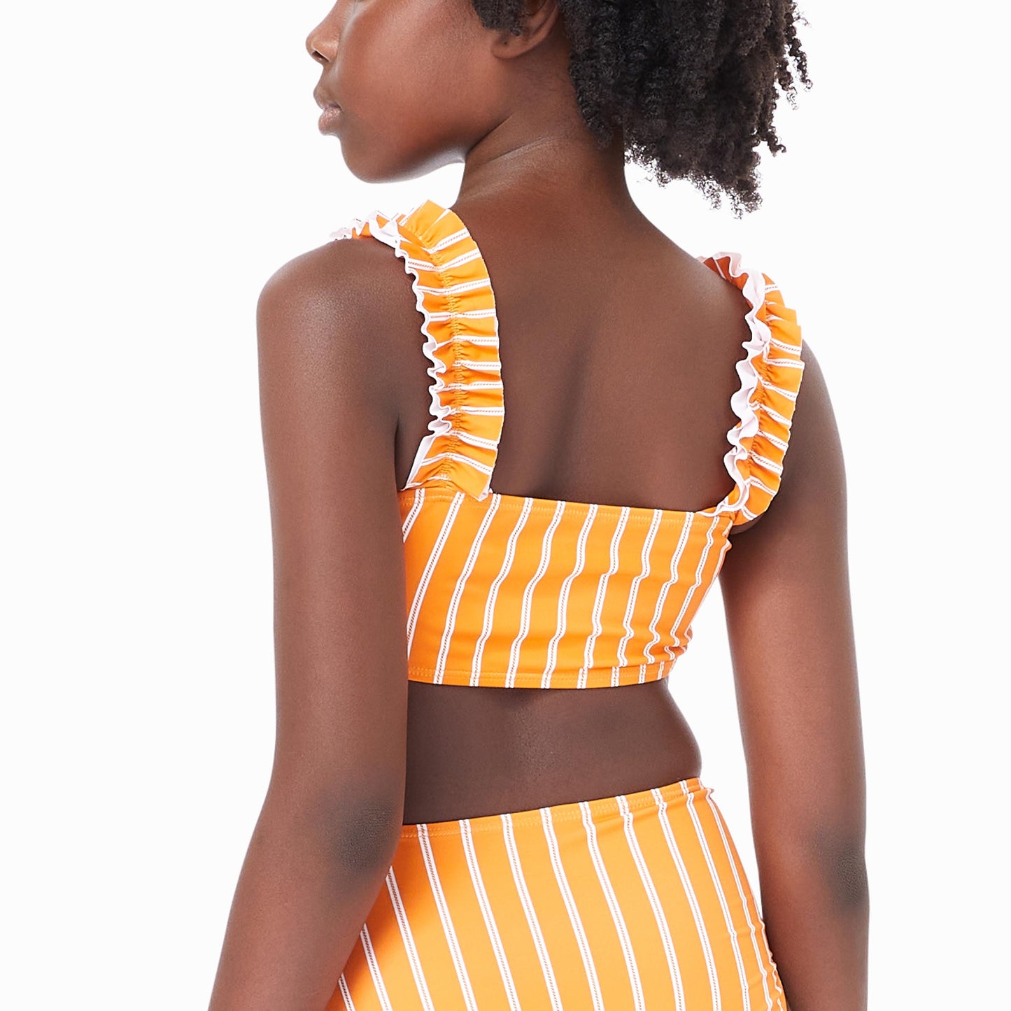 Back of girl wearing orange two-piece swimsuit with white stripes and bow