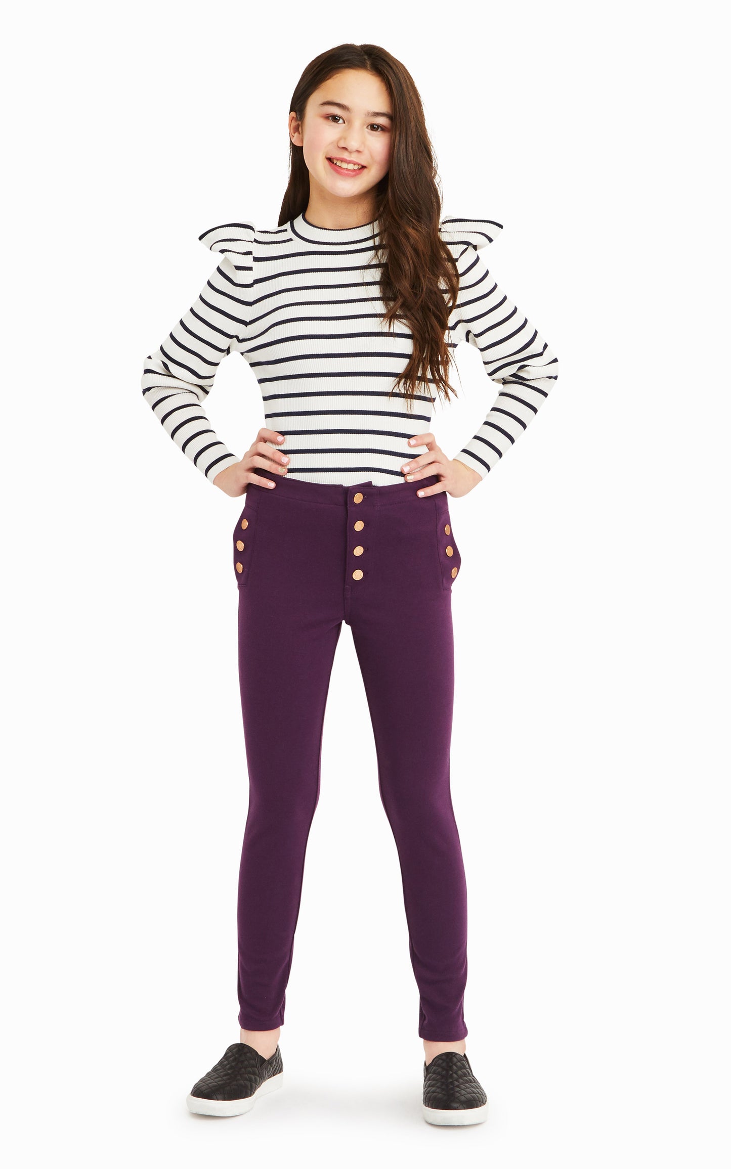 Girl wearing white and black-striped long-sleeve top with purple snap-front pants.