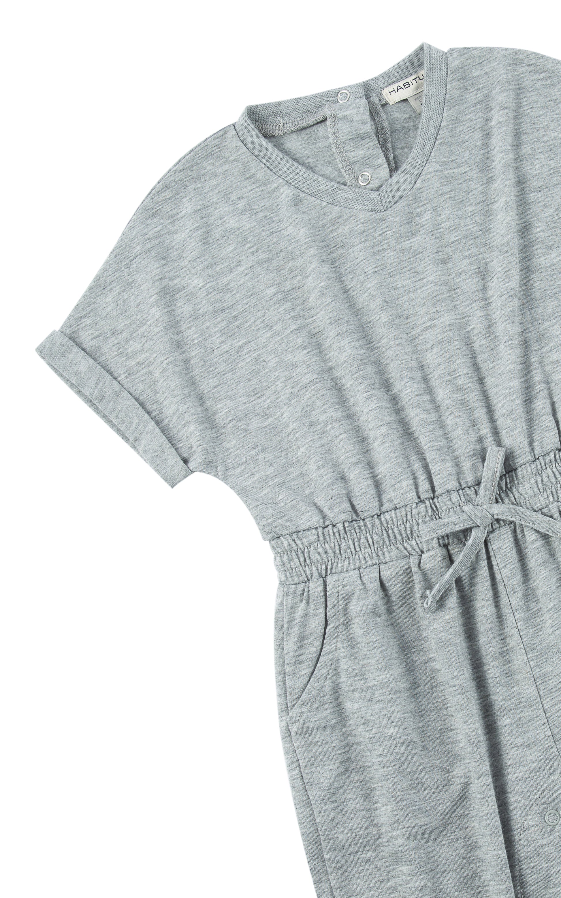 Close up of sleeve and tie waist on gray romper with folded cuff.