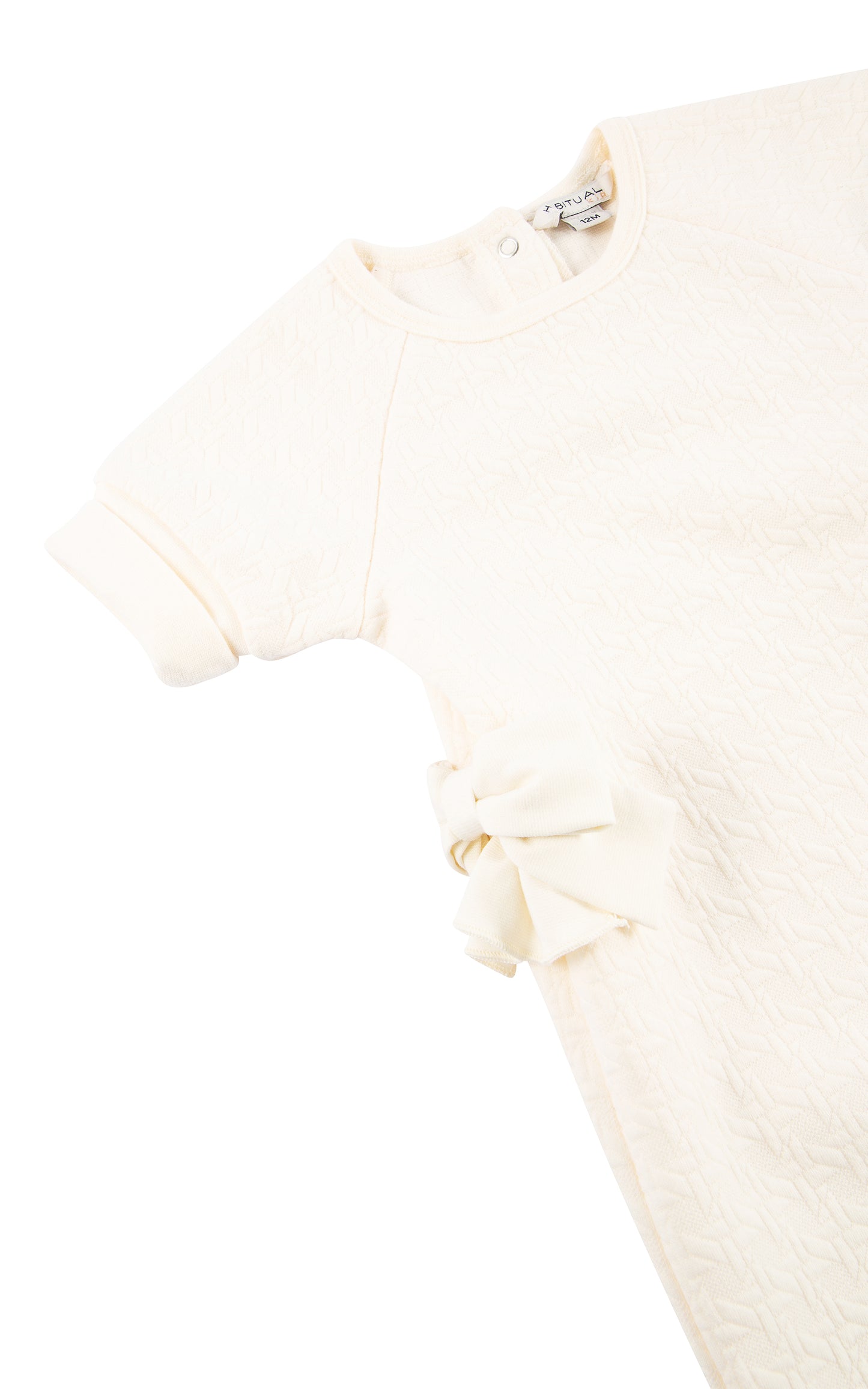 Close up view of top of off-white double knit coverall with cuffed short sleeve and side bow
