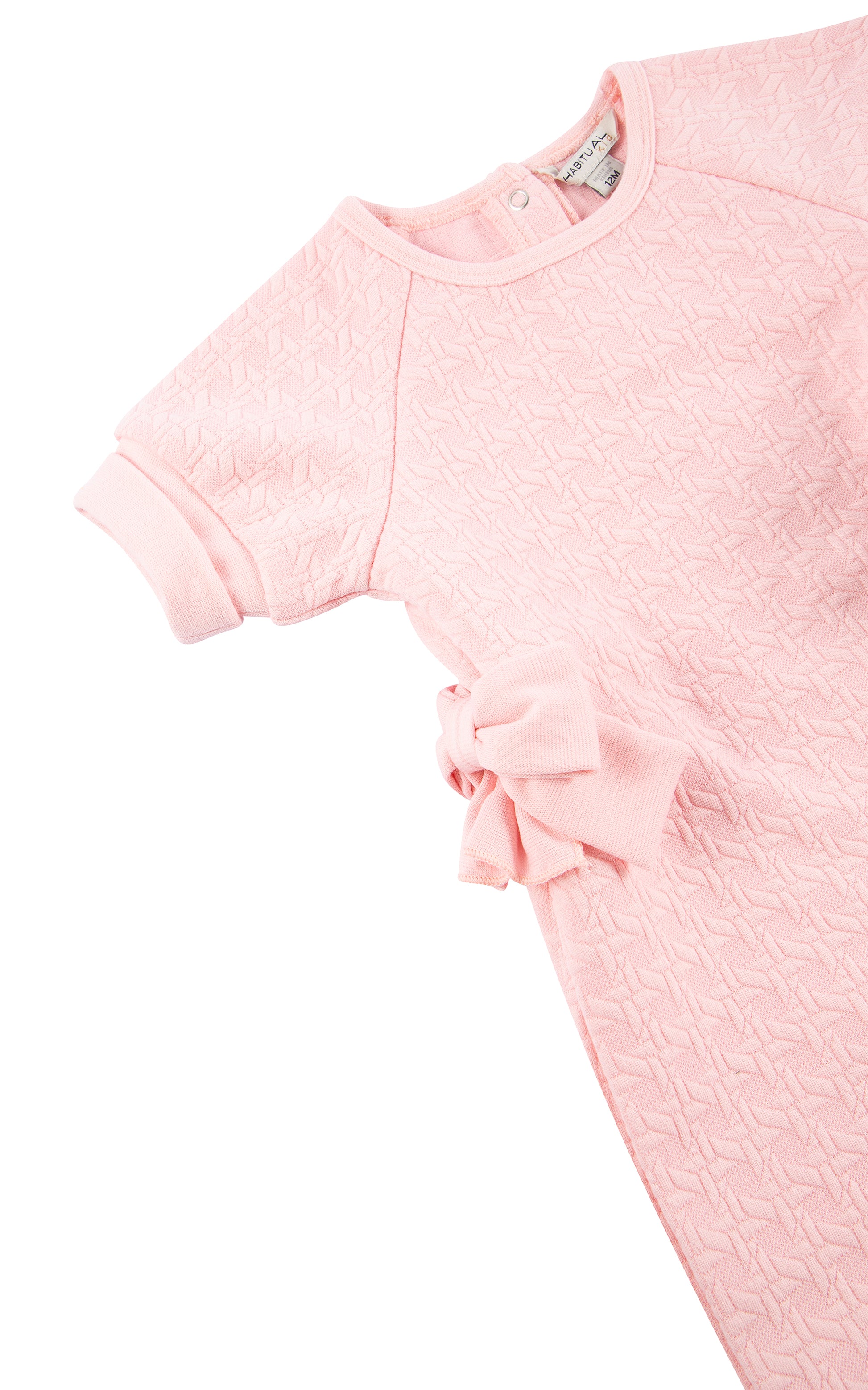 Close up view of top of pink double knit coverall with cuffed short sleeves and side bow 