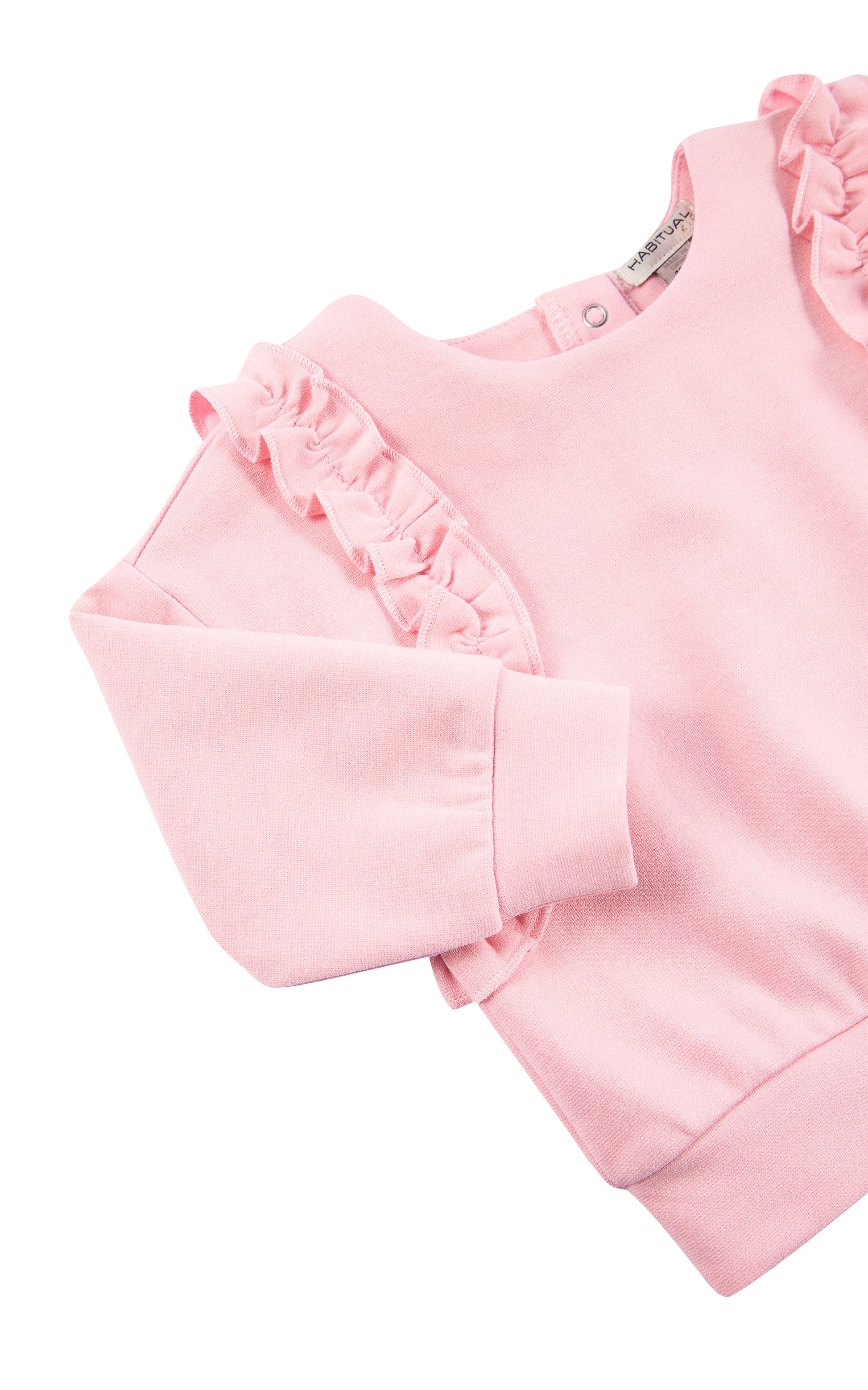 Close up view of top of pink ruched knit set with ruffles stitched from shoulder to mid-waist